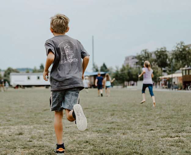 Kids at summer camp playing in their new custom camp shirts